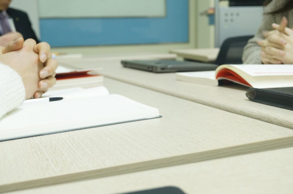 Two people at a table with notebooks and a laptop during a business consultation