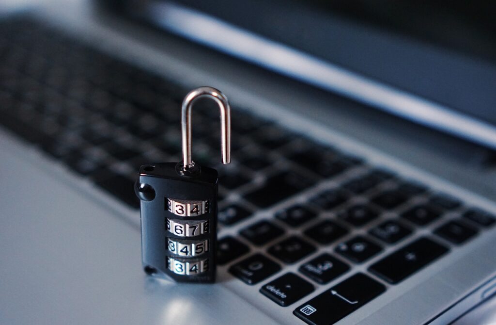 A small combination padlock resting on a laptop keyboard, representing data privacy