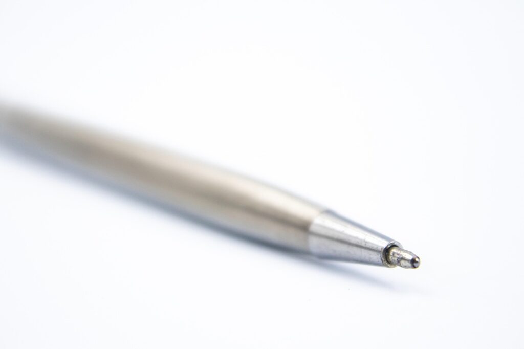 Close-up of a silver pen tip on a plain white background
